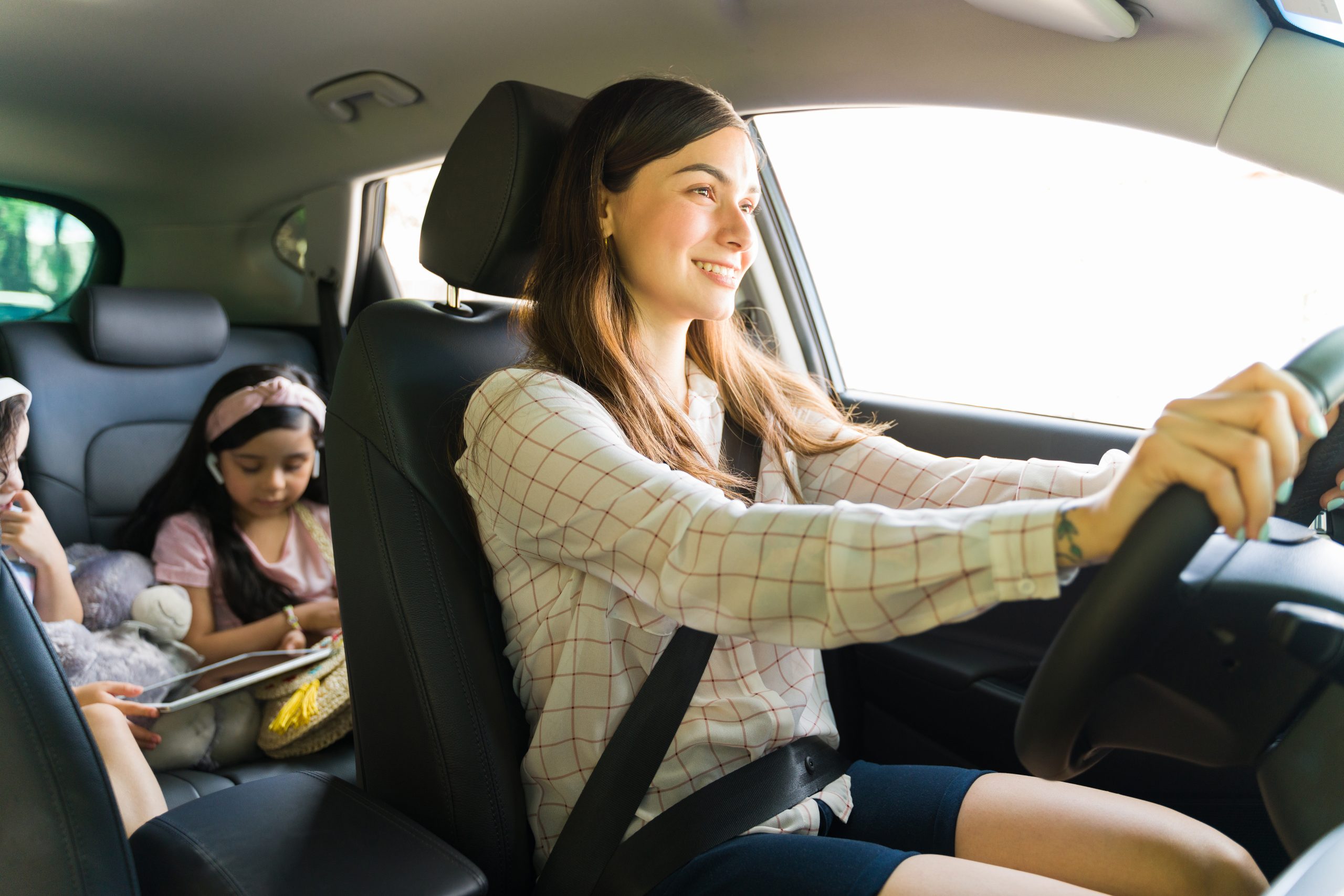 smiling woman driving car with children passengers 2026 01 11 11 13 34 utc